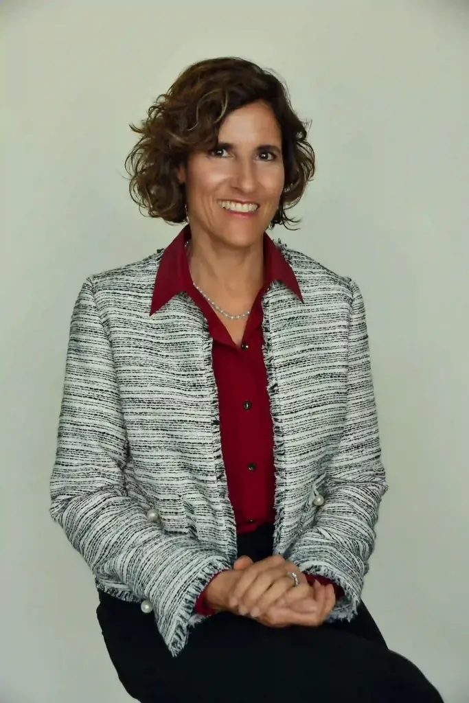 Carolann Mazza, wearing a gray jacket and red blouse